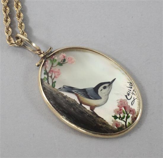 A 12ct gold mounted shell pendant, decorated with a bird, on a 9ct gold chain, pendant 31mm.
